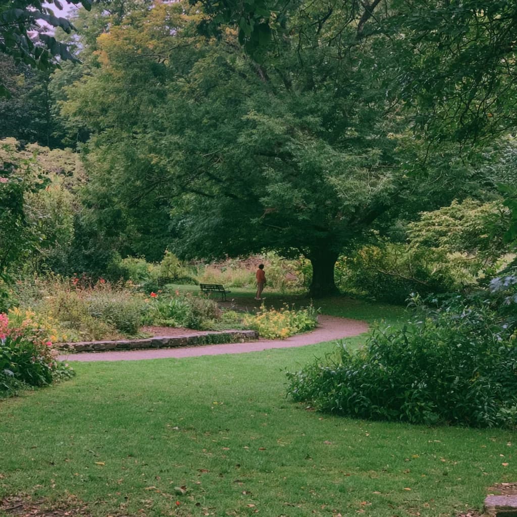 A person pausing beneath a broad tree beside a garden path